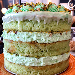<strong>That 70's Pistachio Pudding Cake</strong> <br>pistachio pudding cake + butter + pudding chantilly cream . topped with crunchy vanilla shortbread crumb . pistachio butter cream . roasted pistachios